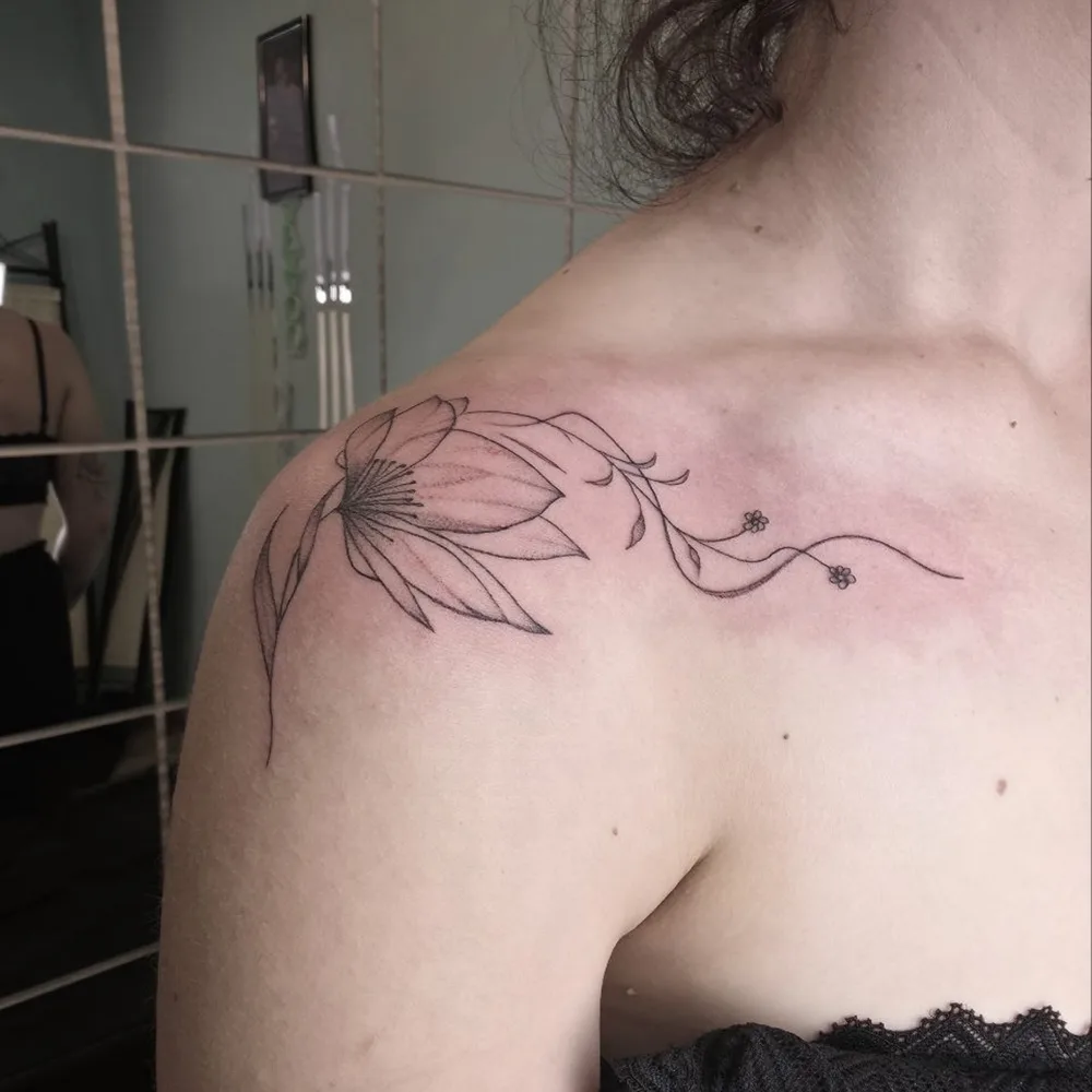 Fargerik akvarell-tatovering av en blomst med teksten «believe»