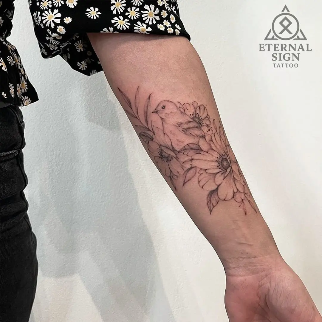 Liten rød blad-tatovering på ringfinger i minimalstisk finline-stil.