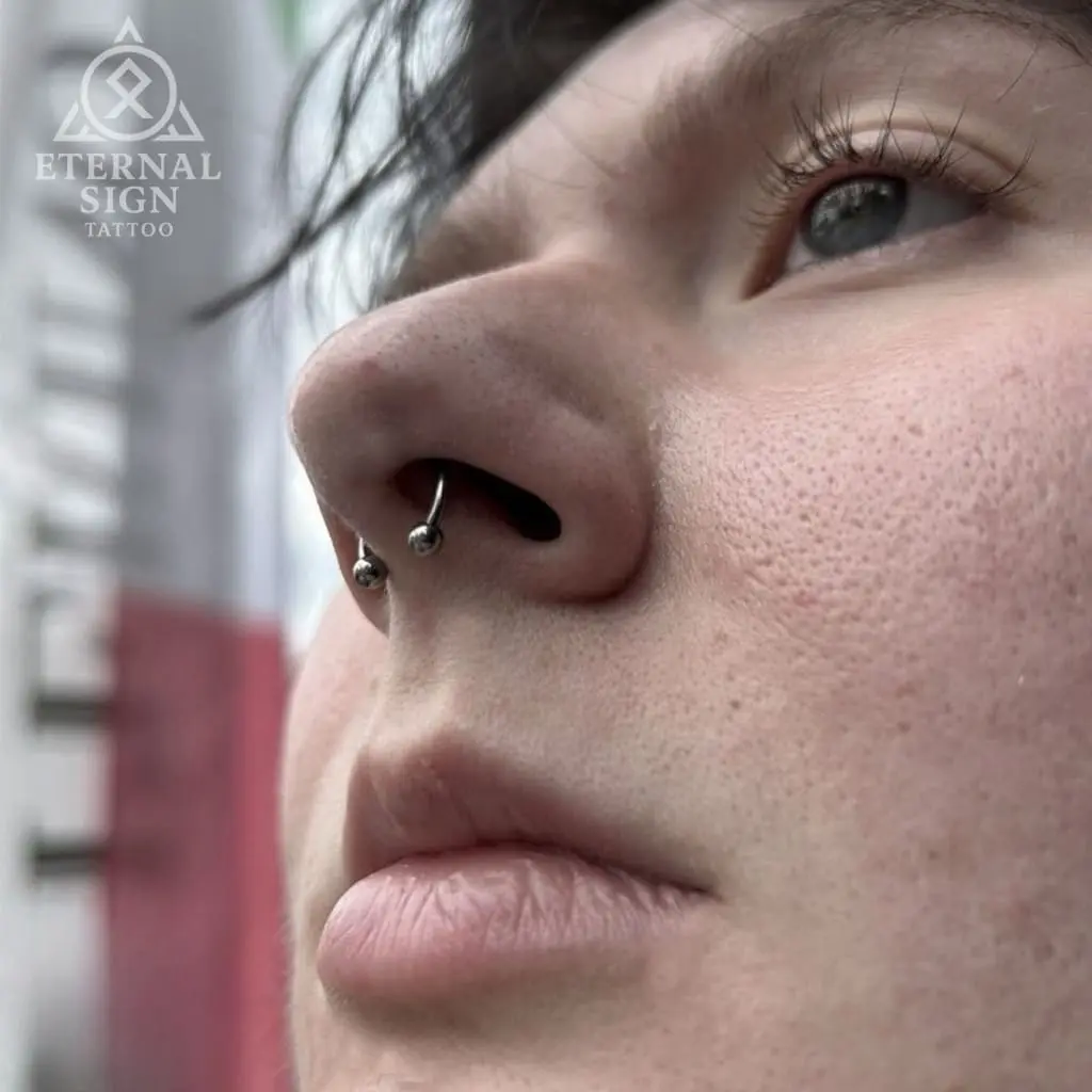 Septum piercing med svart hestesko – minimalistisk ansiktspiercing i nesen